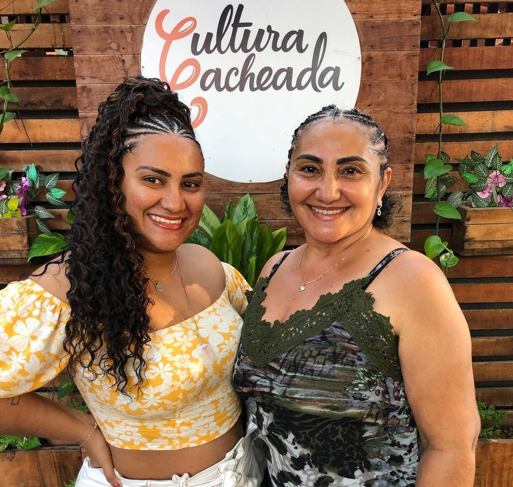 Duas mulheres cacheadas na frente do salão