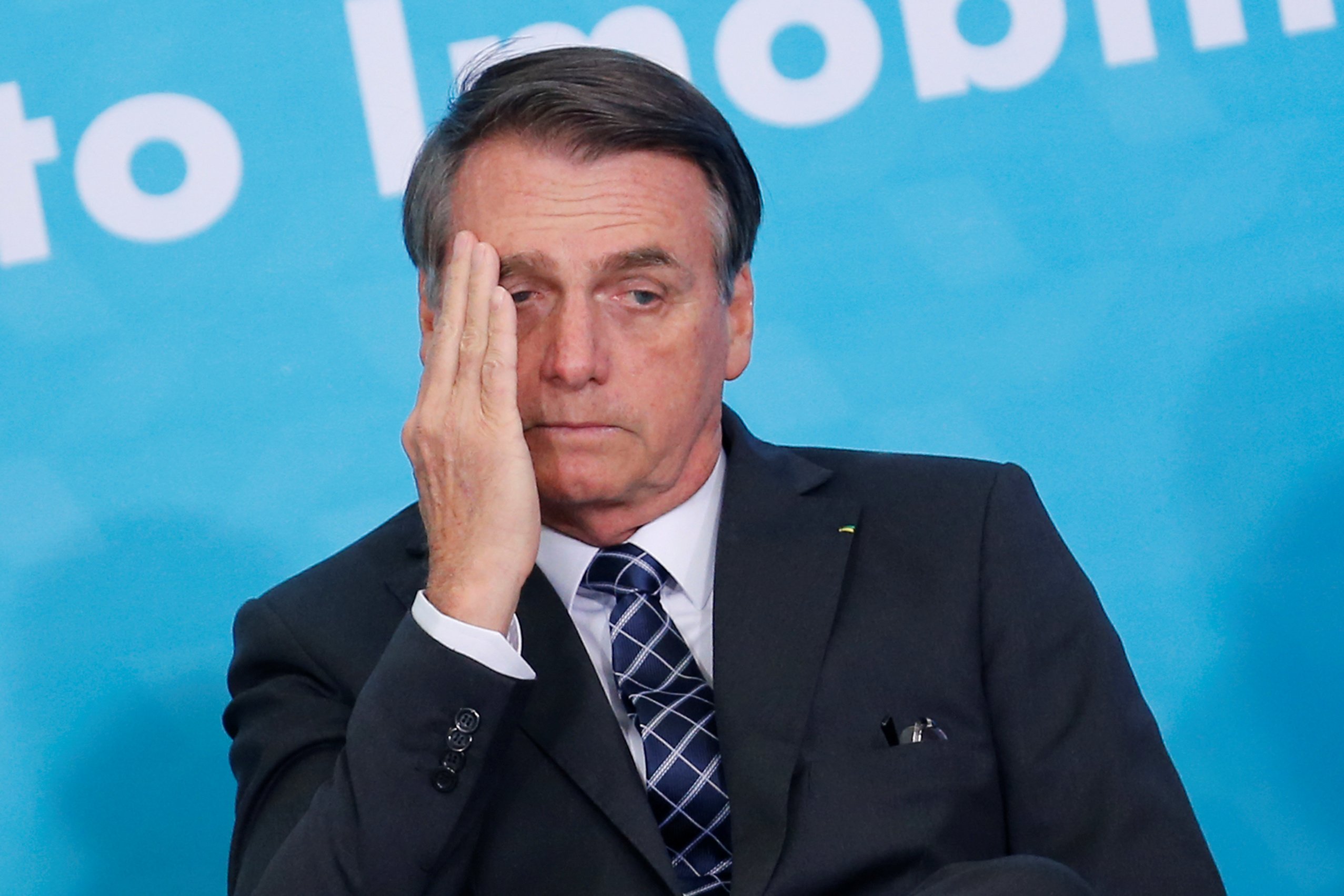 Imagem do Presidente Jair Bolsonaro com a mão no rosto triste