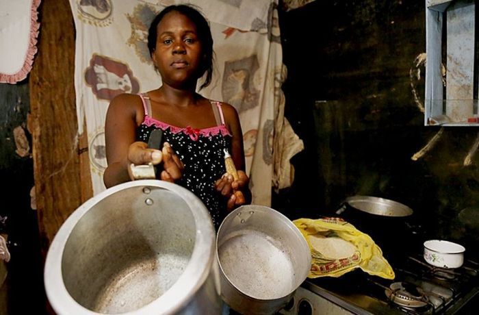 mulher com panela na mão com fome