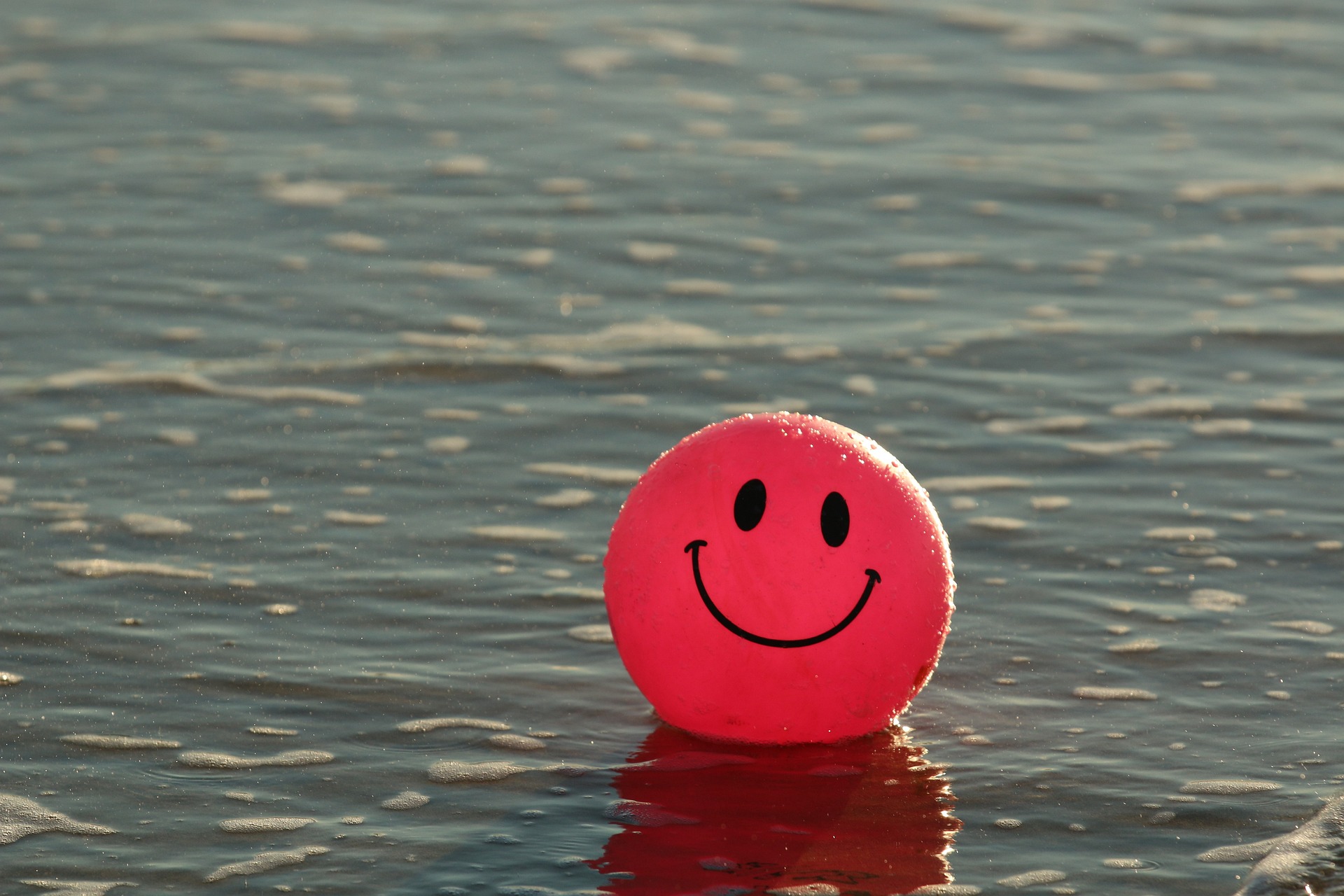 bola de praia expressando felicidade. Ela tem olhos e um sorriso desenhado.